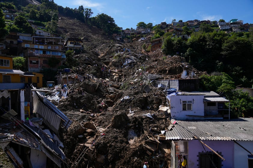 Residents and volunteers look for victims in an area affected by landslides in Petropolis, Brazil, Thursday, Feb. 17, 2022. Rio de Janeiro state’s government has confirmed 94 deaths from floods and mudslides that swept away homes and cars in the city of Petropolis but It’s still unclear how many bodies remained trapped in the mud. (AP Photo/Silvia Izquierdo)