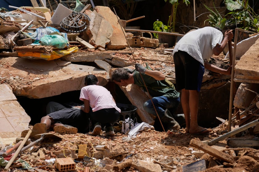 Residents and volunteers look for victims in an area affected by landslides in Petropolis, Brazil, Thursday, Feb. 17, 2022.  Deadly floods and mudslides swept away homes and cars, but even as families prepared to bury their dead, it was unclear how many bodies remained trapped in the mud. (AP Photo/Silvia Izquierdo)