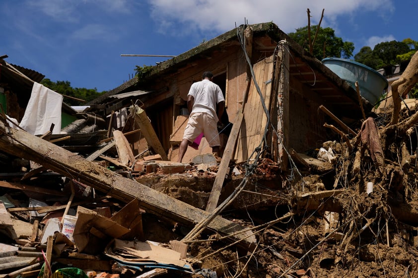 A resident stands in an area affected by landslides in Petropolis, Brazil, Thursday, Feb. 17, 2022.  Deadly floods and mudslides swept away homes and cars, but even as families prepared to bury their dead, it was unclear how many bodies remained trapped in the mud. (AP Photo/Silvia Izquierdo)