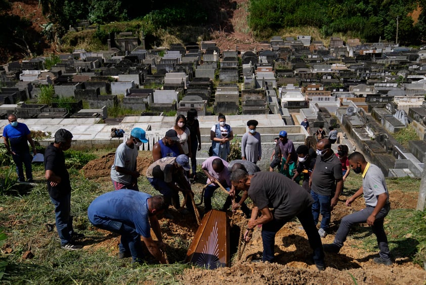 The remains of 54-year-old woman Zilmar Batista, who died in the mudslides, are buried at the Municipal cemetery in Petropolis, Brazil, Thursday, Feb. 17, 2022. Deadly floods and mudslides swept away homes and cars, but even as families buried their dead, it was unclear how many bodies remained trapped in the mud. (AP Photo/Silvia Izquierdo)