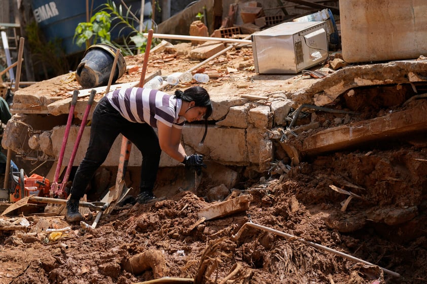 Residents and volunteers look for victims in an area affected by landslides in Petropolis, Brazil, Thursday, Feb. 17, 2022.  Deadly floods and mudslides swept away homes and cars, but even as families prepared to bury their dead, it was unclear how many bodies remained trapped in the mud. (AP Photo/Silvia Izquierdo)