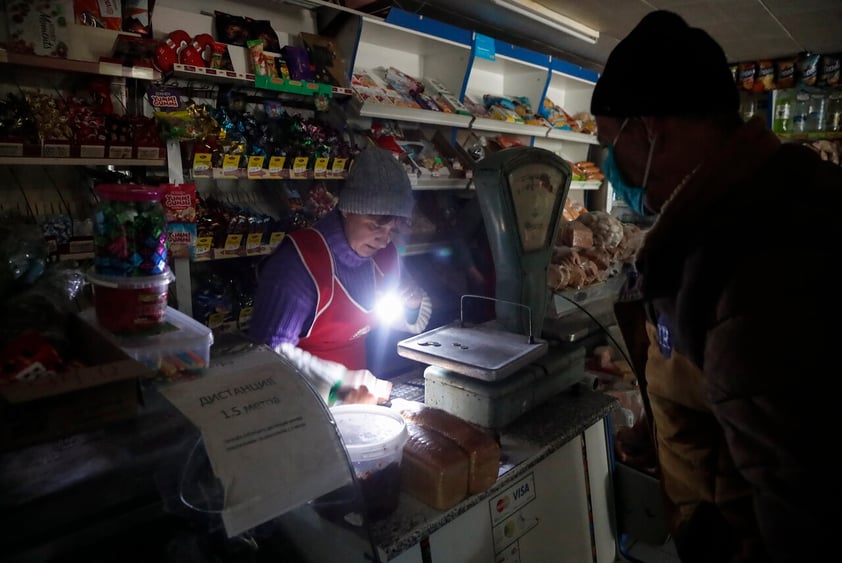 Luhansk (Ukraine), 23/02/2022.- A shop owner uses an torch light due to outage of electricity after shelling, as a local man does shopping in a small shop in the Vibrovka village not far from the pro-Russian militants controlled city of Luhansk, Ukraine, 23 February 2022. Russia on 21 February 2022 recognized the eastern Ukrainian self-proclaimed breakaway regions as independent states and ordered the deployment of peacekeeping troops to the Donbas, triggering an expected series of economic sanctions announcements by Western countries. (Rusia, Ucrania) EFE/EPA/ZURAB KURTSIKIDZE