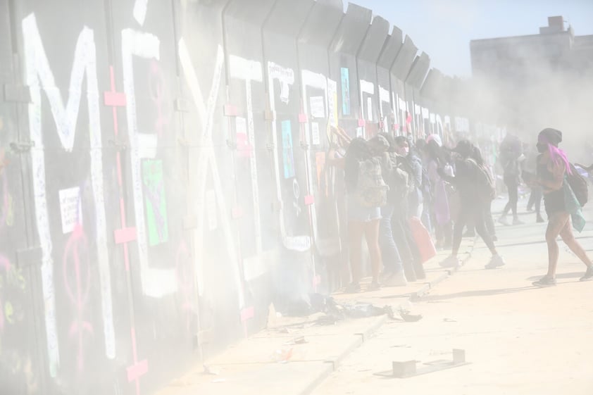 MEX7683. CIUDAD DE MÉXICO (MÉXICO), 08/03/2022.- Mujeres y activistas se protegen hoy de los gases de los extintores lanzados por la policía para dispersarlas, durante las manifestaciones por el Día Internacional de la Mujer en el Zócalo de la Ciudad de México. Miles de mujeres marcharon este martes por las principales ciudades de México para conmemorar el Día Internacional de la Mujer y exigir seguridad en un país en el que asesinan a más de 10 mujeres al día en medio de una radicalización del movimiento feminista y numerosas críticas hacia las autoridades. EFE/Sáshenka Gutiérrez