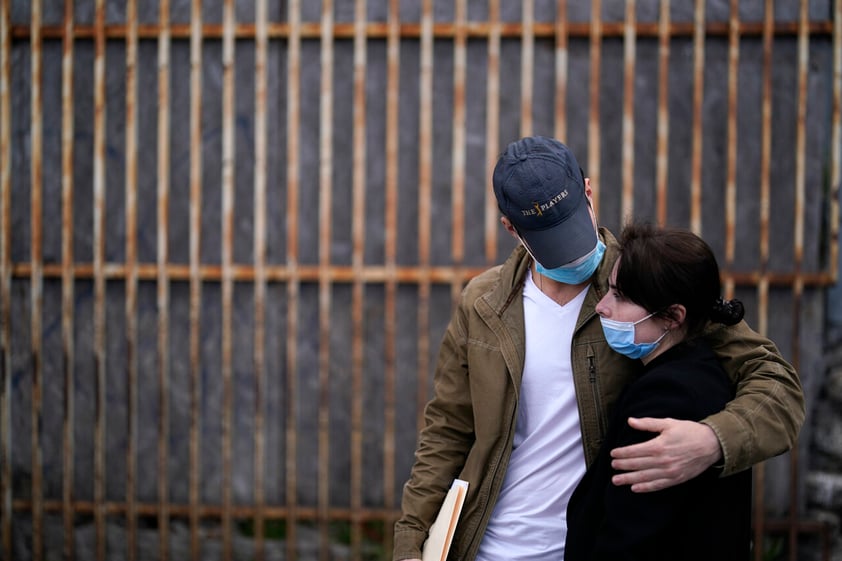 A woman from Ukraine stands at the border with her fiance from the United States as she waits to ask for asylum, Thursday, March 10, 2022, in Tijuana, Mexico. (AP Photo/Gregory Bull)