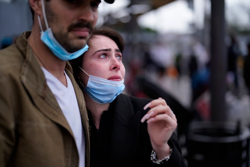 A woman from Ukraine stands at the border with her fiance from the United States as she waits to ask for asylum, Thursday, March 10, 2022, in Tijuana, Mexico. (AP Photo/Gregory Bull)