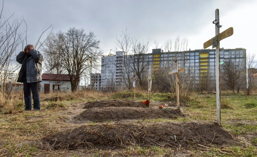 Kyiv (Ukraine), 04/04/2022.- Graves are seen in front of a residential building in Bucha city, which was the recaptured by the Ukrainian army, Kyiv (Kiev) area, Ukraine, 04 April 2022. More than 410 bodies of killed civilians were carried from the recaptured territory in Kyiv's area for exgumation and expert examination. The UN Human Rights Council has decided to launch an investigation into the violations committed after Russia's full-scale invasion of Ukraine as Ukrainian Parliament reported. On 24 February, Russian troops had entered Ukrainian territory in what the Russian president declared a 'special military operation', resulting in fighting and destruction in the country, a huge flow of refugees, and multiple sanctions against Russia. (Rusia, Ucrania) EFE/EPA/OLEG PETRASYUK ATTENTION: GRAPHIC CONTENT