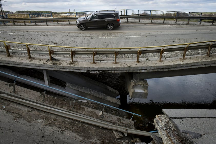 Kyiv (Ukraine), 04/04/2022.- A car drives on a damaged bridge in Bucha city, which was the recaptured by the Ukrainian army, Kyiv (Kiev) area, Ukraine, 04 April 2022. More than 410 bodies of killed civilians were carried from the recaptured territory in Kyiv's area for exgumation and expert examination. The UN Human Rights Council has decided to launch an investigation into the violations committed after Russia's full-scale invasion of Ukraine as Ukrainian Parliament reported. On 24 February, Russian troops had entered Ukrainian territory in what the Russian president declared a 'special military operation', resulting in fighting and destruction in the country, a huge flow of refugees, and multiple sanctions against Russia. (Rusia, Ucrania) EFE/EPA/OLEG PETRASYUK ATTENTION: GRAPHIC CONTENT