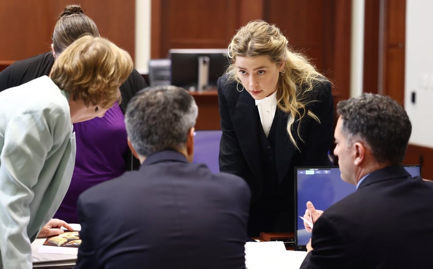 Fairfax (United States), 21/04/2022.- US actress Amber Heard (2-R) speaks with her legal team during the 50 million US dollar Depp vs Heard defamation trial at the Fairfax County Circuit Court in Fairfax, Virginia, USA, 21 April 2022. US actor Johnny Depp's 50 million US dollar defamation lawsuit against his ex-wife Amber Heard that started on 10 April is expected to last five or six weeks. (Estados Unidos) EFE/EPA/JIM LO SCALZO / POOL