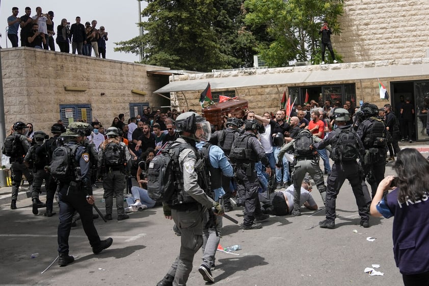 Israeli police confront with mourners as they carry the coffin of slain Al Jazeera veteran journalist Shireen Abu Akleh during her funeral in east Jerusalem, Friday, May 13, 2022. Abu Akleh, a Palestinian-American reporter who covered the Mideast conflict for more than 25 years, was shot dead Wednesday during an Israeli military raid in the West Bank town of Jenin. (AP Photo/Mahmoud Illean)