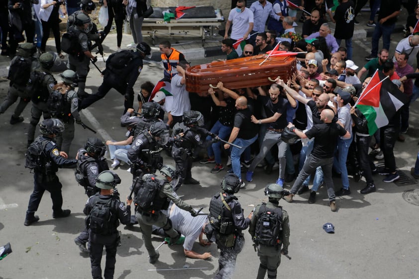 Israeli police confront with mourners as they carry the casket of slain Al Jazeera veteran journalist Shireen Abu Akleh during her funeral in east Jerusalem, Friday, May 13, 2022. Abu Akleh, a Palestinian-American reporter who covered the Mideast conflict for more than 25 years, was shot dead Wednesday during an Israeli military raid in the West Bank town of Jenin. (AP Photo/Maya Levin)