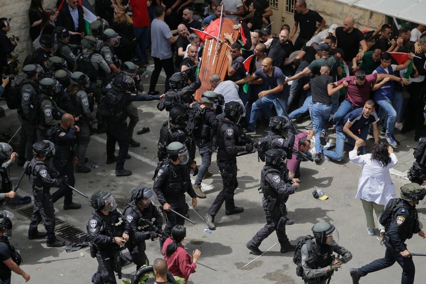 Israeli police confront with mourners as they carry the casket of slain Al Jazeera veteran journalist Shireen Abu Akleh during her funeral in east Jerusalem, Friday, May 13, 2022. Abu Akleh, a Palestinian-American reporter who covered the Mideast conflict for more than 25 years, was shot dead Wednesday during an Israeli military raid in the West Bank town of Jenin. (AP Photo/Maya Levin)