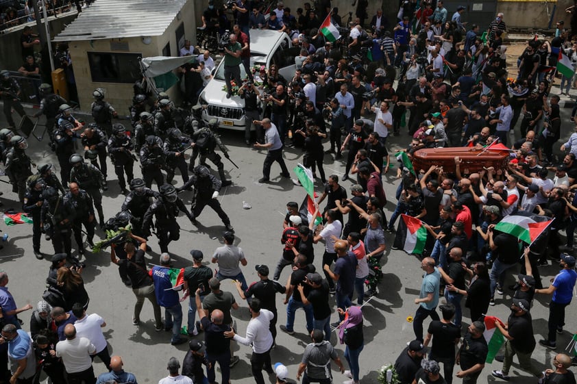 Israeli police confront with mourners as they carry the casket of slain Al Jazeera veteran journalist Shireen Abu Akleh during her funeral in east Jerusalem, Friday, May 13, 2022. Abu Akleh, a Palestinian-American reporter who covered the Mideast conflict for more than 25 years, was shot dead Wednesday during an Israeli military raid in the West Bank town of Jenin. (AP Photo/Maya Levin)