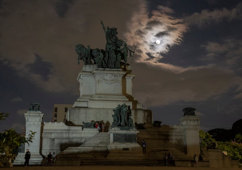 A full moon rises behind the Independence monument in Sao Paulo, Brazil, Sunday, May 15, 2022. (AP Photo/Andre Penner)