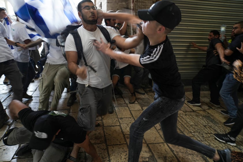 Palestinian and Jewish youths clash at Damascus Gate in Jerusalem's Old City as Israelis mark Jerusalem Day, an Israeli holiday celebrating the capture of the Old City during the 1967 Mideast war. Sunday, May 29, 2022. Israel claims all of Jerusalem as its capital. But Palestinians, who seek east Jerusalem as the capital of a future state, see the march as a provocation. Last year, the parade helped trigger an 11-day war between Israel and Gaza militants. (AP Photo/Mahmoud Illean)