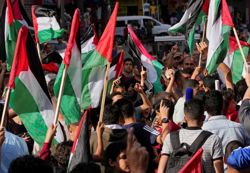 Hamas supporters wave Palestinian flags during a protest against the Israeli flags march to mark Jerusalem Day, an Israeli holiday celebrating the capture of the Old City of Jerusalem during the 1967 Mideast war, in the Jebaliya refugee camp, northern Gaza Strip, Sunday, May 29, 2022. (AP Photo/Adel Hana)