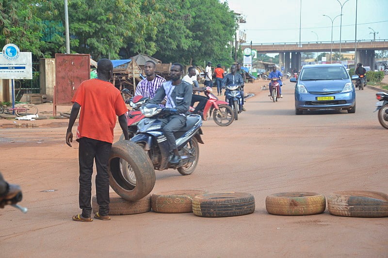 Ougadougou (Burkina Faso), 30/09/2022.- A man places tyres across a road in Ouagadougou, Burkina Faso, 30 September 2022. Gunshots have been heard near the presidential palace in Ouagadougou with what some residents claim to be an alleged coup attempt. Access has been blocked by the military to some government buildings including the national assembly and the national broadcaster. In January 2022 the current head of state, Lt-Col Paul-Henri Damiba, ousted President Roch Kabore through a coup. Lieutenant Colonel Paul-Henri Damiba has called for calm. (Golpe de Estado) EFE/EPA/ASSANE OUEDRAOGO