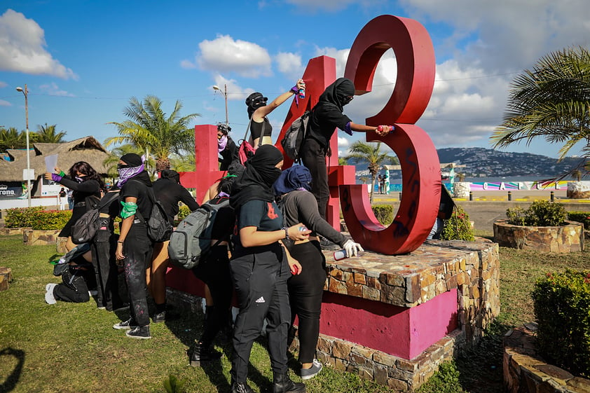 MEX9162. ACAPULCO (MÉXICO), 08/03/2023.- Varias mujeres realizan pintadas en el monumento a los 43 de Ayotzinapa hoy, durante una marcha con motivo del Día Internacional de la Mujer, en el puerto de Acapulco, estado de Guerrero (México). En México, miles de mujeres también marcharon este miércoles en las ciudades de Monterrey y Guadalajara, dos de las más grandes e importantes del país para protestar y denunciar la violencia machista en el Día Internacional de la Mujer. EFE/ Francisco Guasco