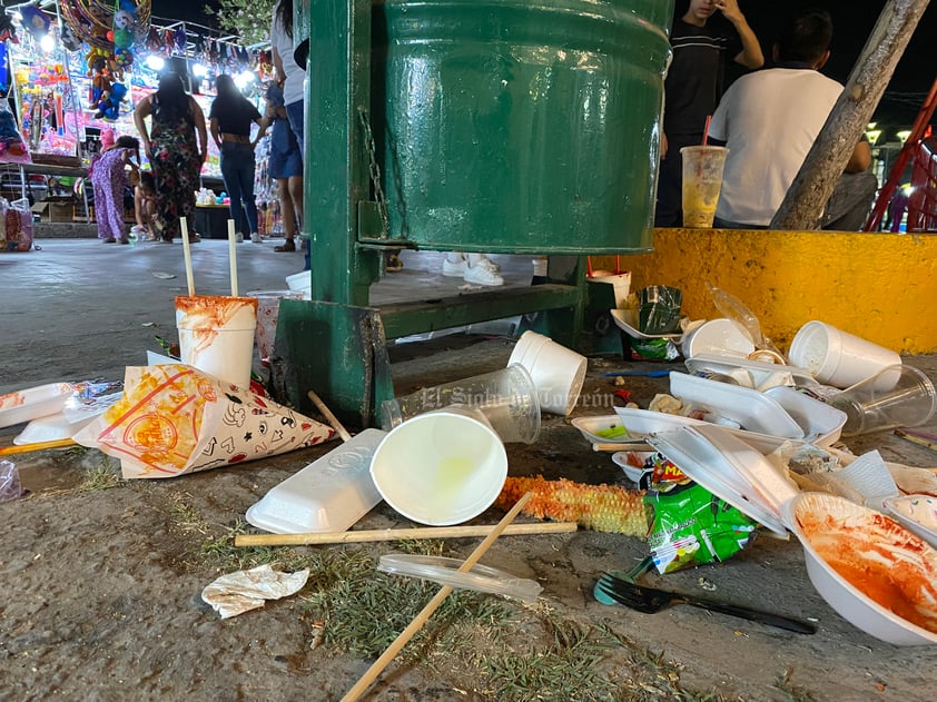 Basura, justo junto a un bote para recolectarla.