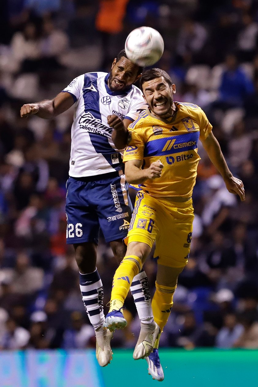 MEX3449. PUEBLA (MÉXICO), 30/11/2023.- Bryan Angulo (i) del Puebla disputa hoy el balón con Juan Pablo Vigón de Tigres, durante la ida de los cuartos de final del torneo Apertura 2023 de la Liga MX, en el estadio Cuauhtémoc en Puebla (México). EFE/Hilda Ríos