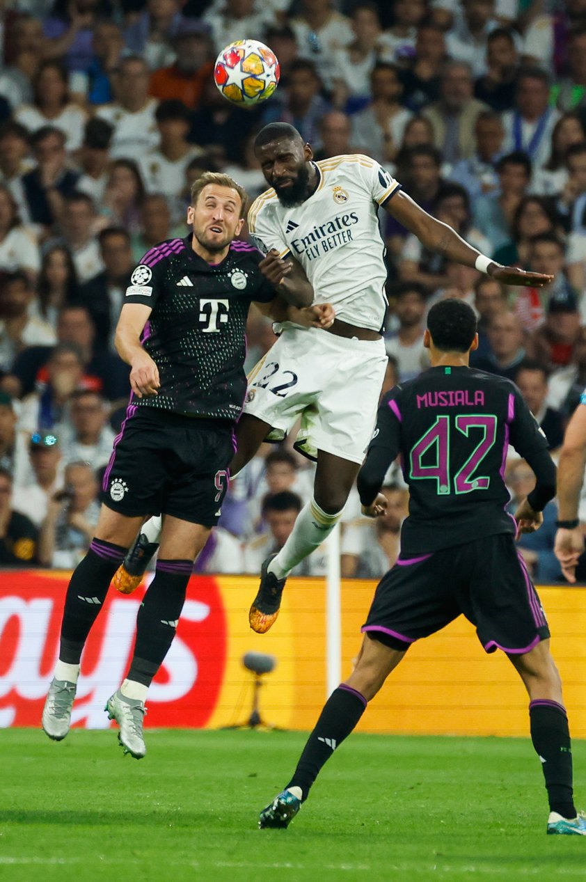 MADRID, 08/05/2024.- El defensa del Real Madrid Antonio Rüdiger (c) cabecea un balón ante Harry Kane (i), del Bayern, durante el partido de vuelta de las semifinales de la Liga de Campeones que Real Madrid y Bayern de Múnich disputan hoy miércoles en el estadio Santiago Bernabéu. EFE/Juanjo Martín