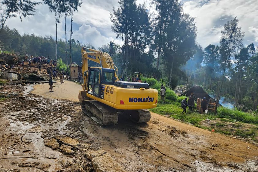 Villagers use heavy machinery to search through a landslide in Yambali in the Highlands of Papua New Guinea, Sunday, May 26, 2024. The International Organization for Migration feared Sunday the death toll from a massive landslide is much worse than what authorities initially estimated. (Mohamud Omer/International Organization for Migration via AP)