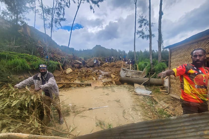 CORRECTS TO YAMBALI FOR LOCATION, NOT POGERA - Villagers search through a landslide in Yambali in the Highlands of Papua New Guinea, Sunday, May 26, 2024. The International Organization for Migration has increased its estimate of the death toll from a massive landslide Friday May 24 in Papua New Guinea to more than 670. (Mohamud Omer/International Organization for Migration via AP)