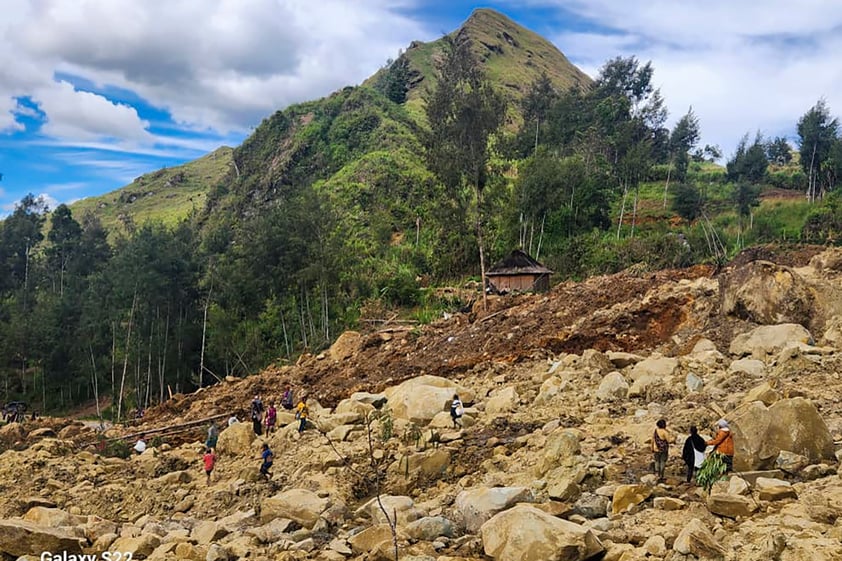 In this image supplied by the International Organization for Migration, villagers search amongst the debris from a landslide in the village of Yambali in the Highlands of Papua New Guinea, Monday, May 27, 2024. (Mohamud Omer/International Organization for Migration via AP)