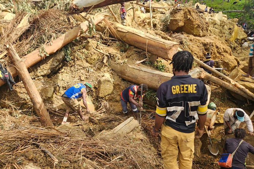 In this image supplied by the International Organization for Migration, villagers search amongst the debris from a landslide in the village of Yambali in the Highlands of Papua New Guinea, Monday, May 27, 2024. (Mohamud Omer/International Organization for Migration via AP)