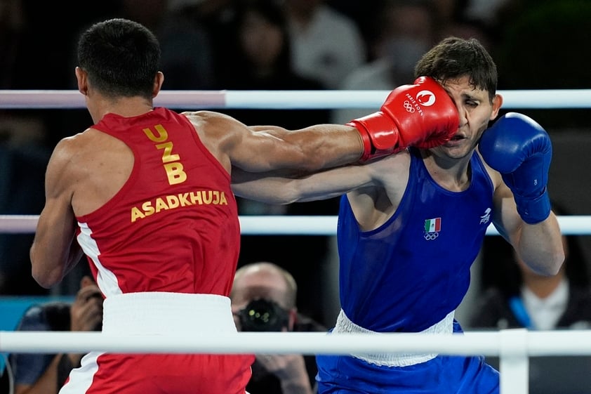 El uzbeco Asadkhuja Muydinkhujaev golpea al mexicano Marco Verde en la pelea de box olímpico, categoría de 71 kilogramos, el viernes 9 de agosto de 2024, en París (AP Foto/John Locher)