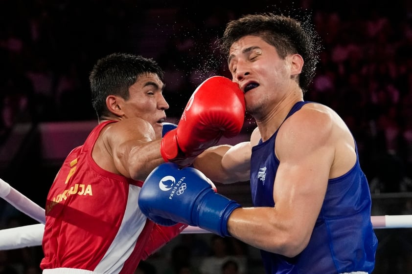 Uzbekistan's Asadkhuja Muydinkhujaev, left, fights Mexico's Marco Verde in their men's 71 kg final boxing match at the 2024 Summer Olympics, Friday, Aug. 9, 2024, in Paris, France. (AP Photo/Ariana Cubillos)