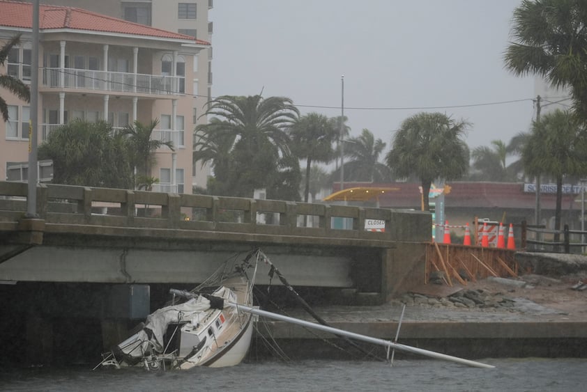 A boat damaged in Hurricane Helene rests against a bridge ahead of the arrival of Hurricane Milton, in South Pasadena, Fla., Wednesday, Oct. 9, 2024. (AP Photo/Rebecca Blackwell)