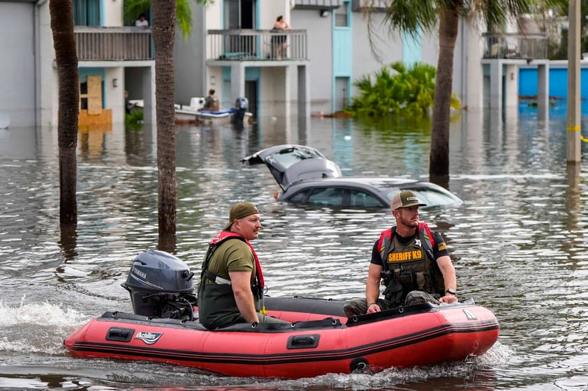 A water rescue boat moves in flood waters at an apartment complex in the aftermath of Hurricane Milton, Thursday, Oct. 10, 2024, in Clearwater, Fla. (AP Photo/Mike Stewart)