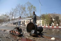 Restos. Bomberos limpian el lugar donde sucedió el ataque. El de ayer se suma a otros atentados en la capital afgana este año. (AP)