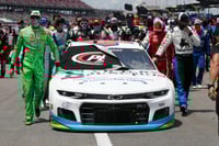 Pilotos y miembros de los diferentes equipos escoltaron el auto de Bubba Wallace previo a la carrera de ayer. (AP)