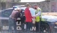 Un oficial del área de peritos de Tránsito del Estado fue grabado cuando presuntamente recibía el soborno de un automovilista y su familia, en el municipio de Morelia. (ESPECIAL)