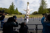 La exatleta olímpica Aya Terakawa (c) corre con la antorcha olímpica durante el primer día de la ronda de relevos en un antiguo sitio de ferias en Suita, al norte de Osaka, Japón. (AP)
