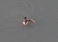 El hombre aparece portando un objeto que se presume se trata de un arma larga.