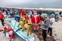 Entusiasmo. Los entusiastas surfistas en Estados Unidos , vestidos como Papá Noel, asisten al evento anual Surfing Santas en Cocoa Beach, Florida. Según los organizadores, lo que comenzó como una pequeña reunión familiar se ha convertido en un gran evento que atrae a multitudes de todo el mundo. para celebrar la temporada navideña al más puro estilo playero.