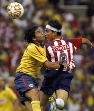 El defensa del América, Ricardo Rojas, lucha por el balón con el delantero de Chivas, Omar Bravo en el juego de ida de la semifinal del Torneo Clausura 2007, disputado en el Estadio Azteca; América se impuso 1-0. (Fotografías de EFE y Jam Media)