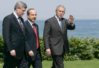 El presidente de los Estados Unidos George Bush (der.) saluda mientras camina junto al primer ministro de Canadá Stephen Harper (izq.) y el presidente mexicano Felipe Calderón, durante el último día de la cumbre del G8 en Heiligendamm, Alemania, hoy viernes 8 de junio. (EFE)