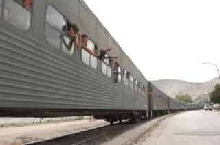 Soldados saludan desde el tren a su paso por la colonia Miguel Hidalgo, en Torreón, en uno de los pocos trenes de pasajeros que pasan por la ciudad. El convoy también llevaba equipo militar como tanquetas. La Secretaría de la Defensa no informó si las tropas iban de paso o si serán destacadas en Torreón para reforzar la seguridad.