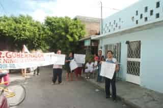 Los vecinos de la Privada Manlio Gómez Uranga muestran las pancartas que llevarán a la capital del Estado para solicitar ayuda al gobernador.