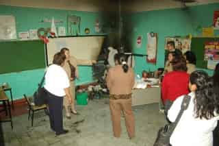 Personal de la escuela primaria 18 de Marzo de Gómez Palacio, inspecciona el salón del tercero “A”, donde se registró un conato de incendio y generó la evacuación de mil 150 alumnos.