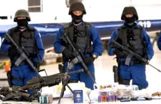 Miembros de la Policía Federal Preventiva (PFP) muestran en el aeropuerto de Ciudad de México, parte de un arsenal que se le decomisó a presuntos miembros de un cartel del narcotráfico. (EFE)
