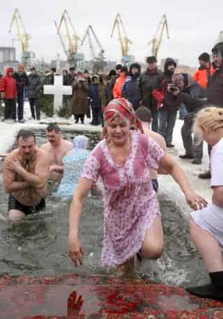 Creyentes ortodoxos rusos se bañan en el agua helada durante la celebración de la Epifanía en Moscú, Rusia. (EFE)
