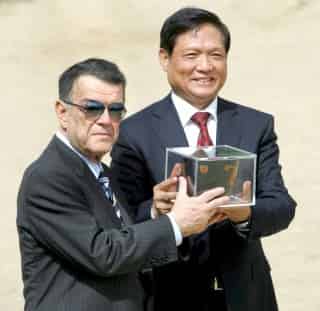 El presidente del Comité Olímpico Griego, Minos Kyriakou (izq.), le pasa el caldero de la llama olímpica al presidente del Comité Organizativo de los Juegos Olímpicos de Pekín 2008, Liu Qi, durante la ceremonia de encendido de la antorcha olímpica frente al templo de Hera en la Antigua Olimpia. (EFE)