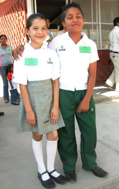 Dos alumnos de la escuela primaria Agustín Melgar modelaron los nuevos uniformes durante la entrega de becas “Compartiendo Esfuerzos” para que los maestros, padres de familia y sus compañeros, los conocieran.