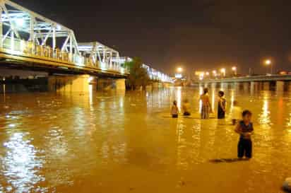 Cientos de laguneros esperaron hasta anoche para ver pasar el Río Nazas. El agua llegó hasta las 9 de la noche a la zona conurbada y poco a poco fue aumentando su caudal. (Fotografía de Ramón Sotomayor C.)