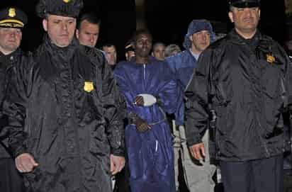 En prisión. La Policía y agentes de Brigada de Investigación Criminal escoltan al sospechoso pirata somalí Abdiwali Abdiqadir Muse en la oficina central de Brigada de Investigación Criminal en Nueva York el pasado 20 de abril. Muse es el pirata sobreviviviente en la toma de rehén de capitán de barco comercial Richard Phillips, el Alabama Maersk.