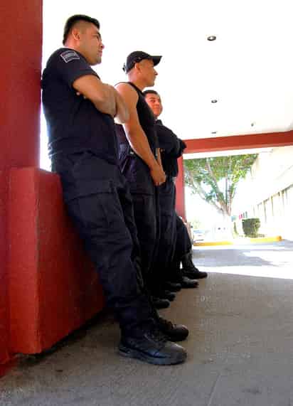 Esperan a los demás. Policías federales esperan a las afueras del hotel que terminen sus compañeros el examen antidoping para tomar medidas.